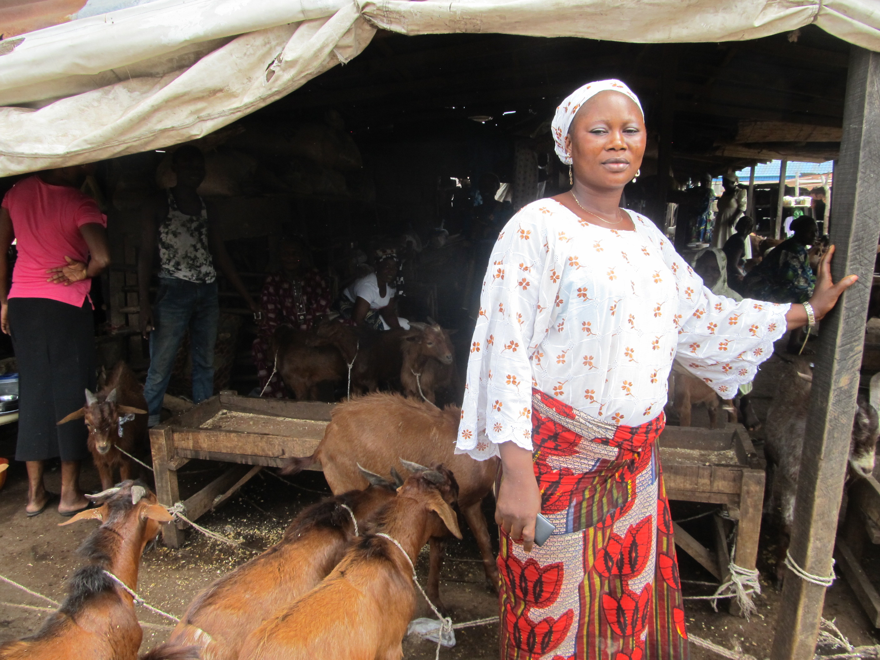 Woman stands by goat